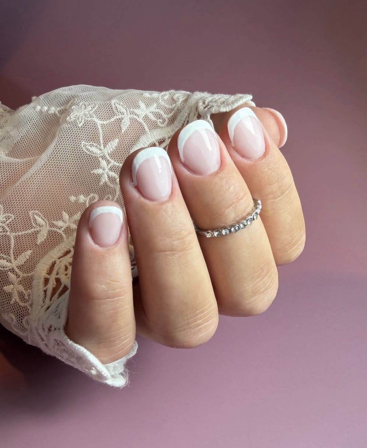 Korte ovale nagels met roze basis en witte French tips