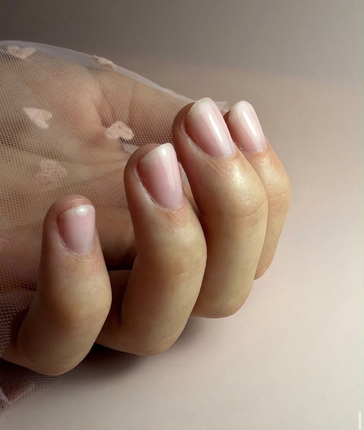 Korte natuurlijke nagels met subtiele roze BIAB glans